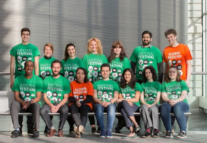 A group of smiling volunteers wear brightly coloured Festival tshirts