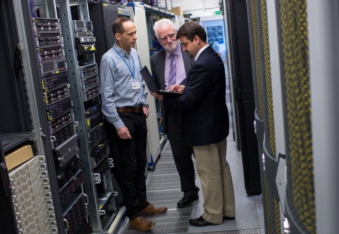 Imperial cyber security researchers standing amoungst the College's computer mainframes