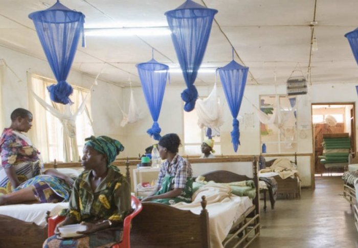 Mothers in a hospital with their children surrounded by bednets