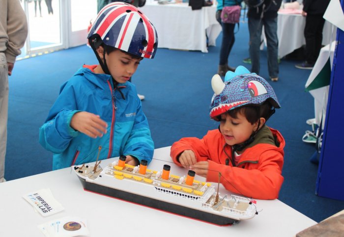 Two children playing with a LEGO Titanic at the Imperial Hazelab display