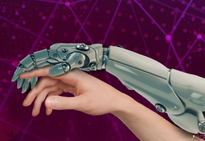 Robot arm against a human arm. Robot hand is holding a human finger in a protective stance.
