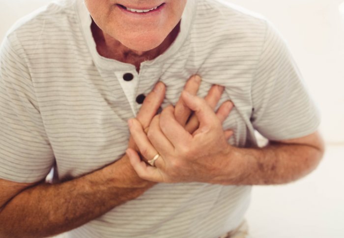 Image of an older man clutching his chest