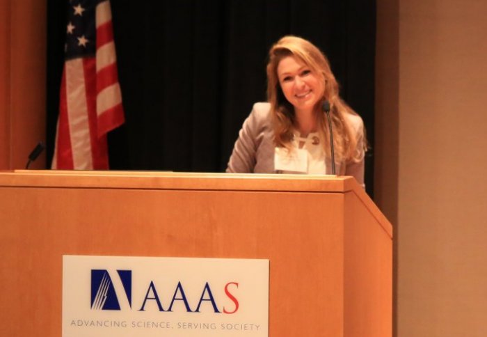 Miriam Aczel stands at a podium accepting her AAAS essay award