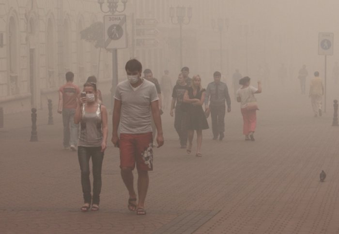 People in masks on a very smoggy street