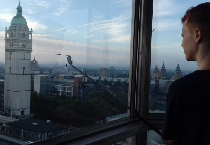 Man on the roof of a building holding out a trace gas release mechanism