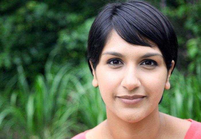 Journalist Angela Saini with a green foliage background