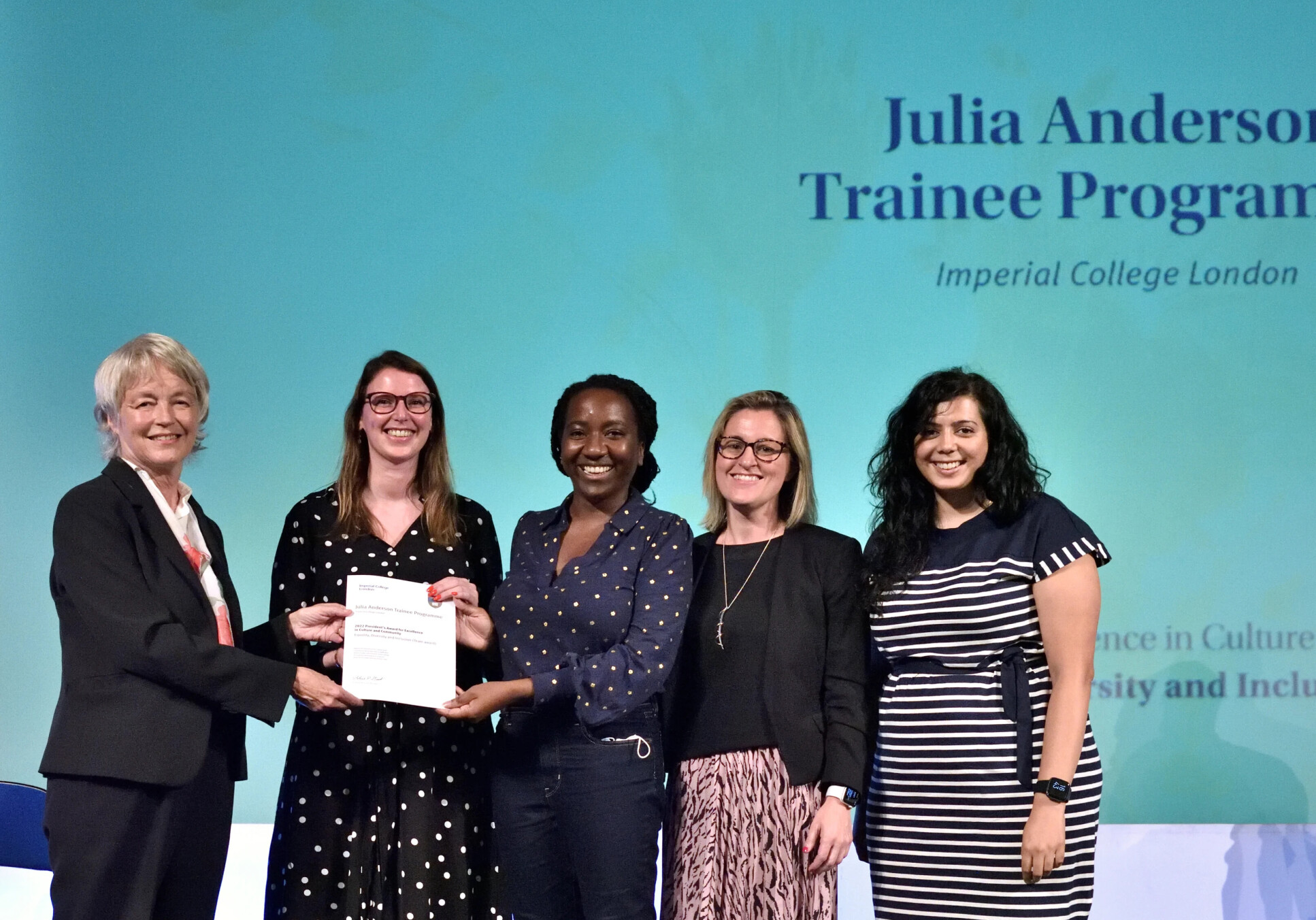 Julia Anderson Training Programme team collecting the 'President's Award' certificate on stage