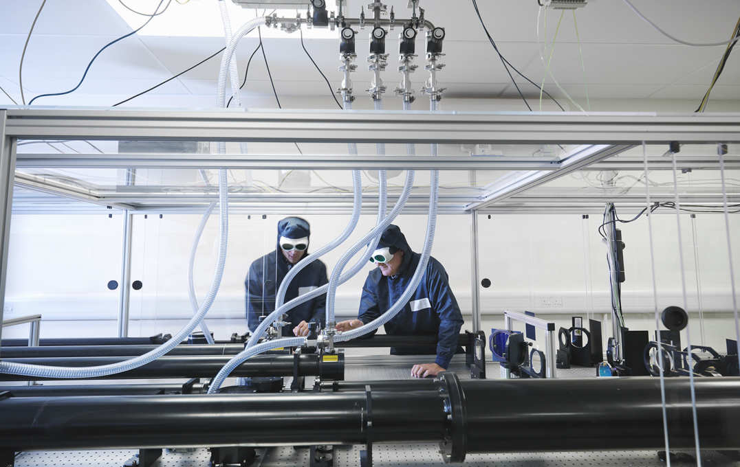 Researchers in laser goggles working with laser equipment