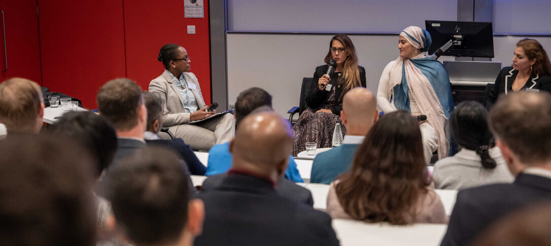 A woman speaking into a microphone at an alumni pnel event
