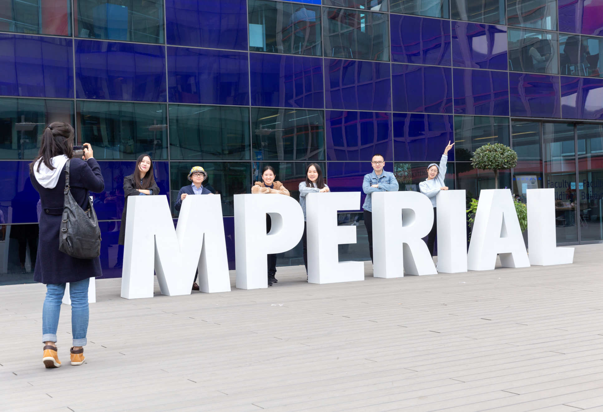 big white letters spelling Imperial with people posing behind them
