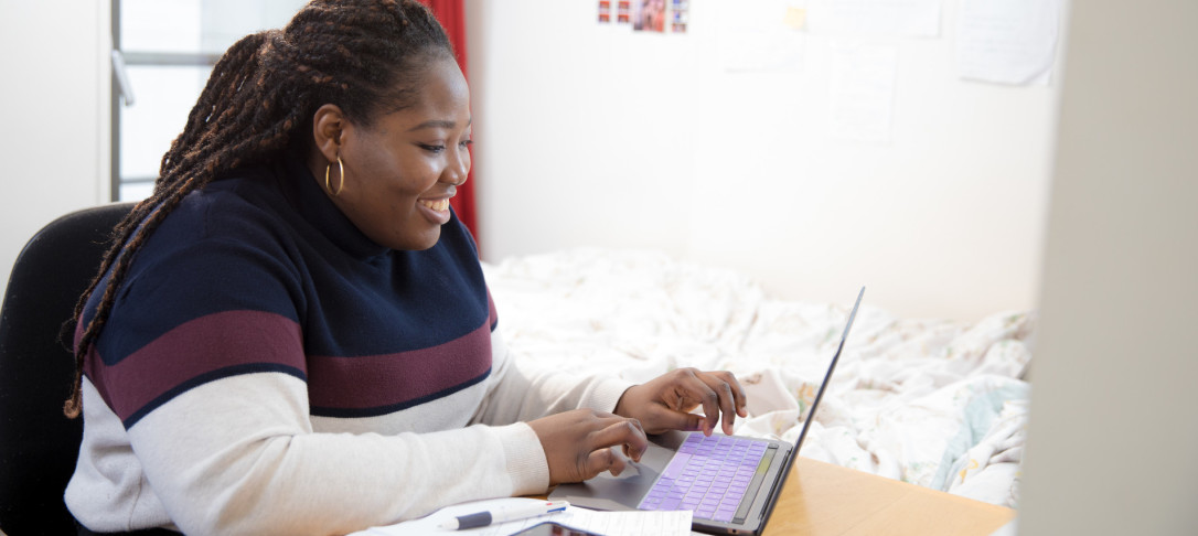 A medical student working at a laptop in halls