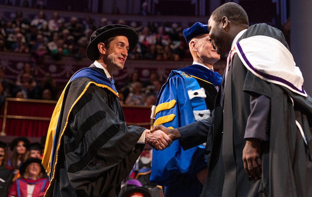 A Professor shaking hands with a new graduate on stage