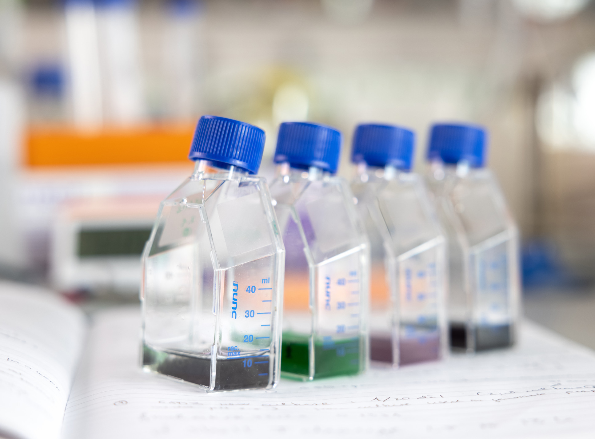 Four flasks with brown and green liquid.