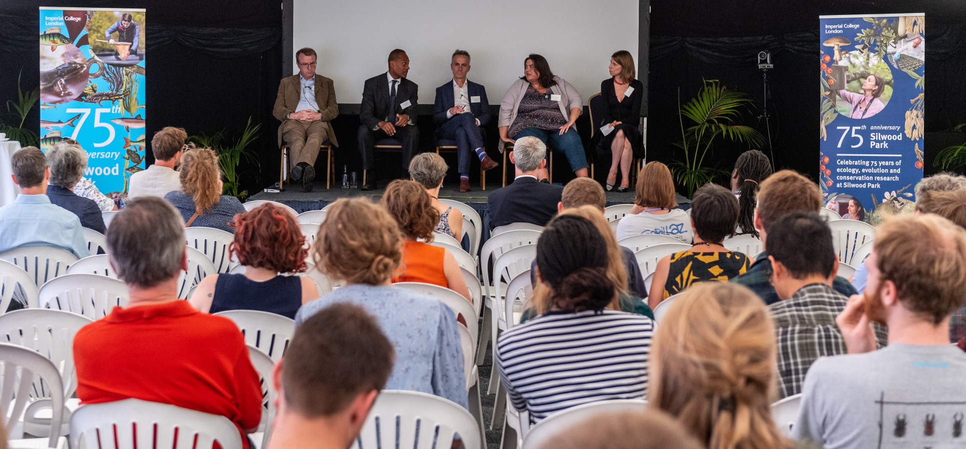 The panel engage in a lively discussion on stage as the audience listen and ask questions