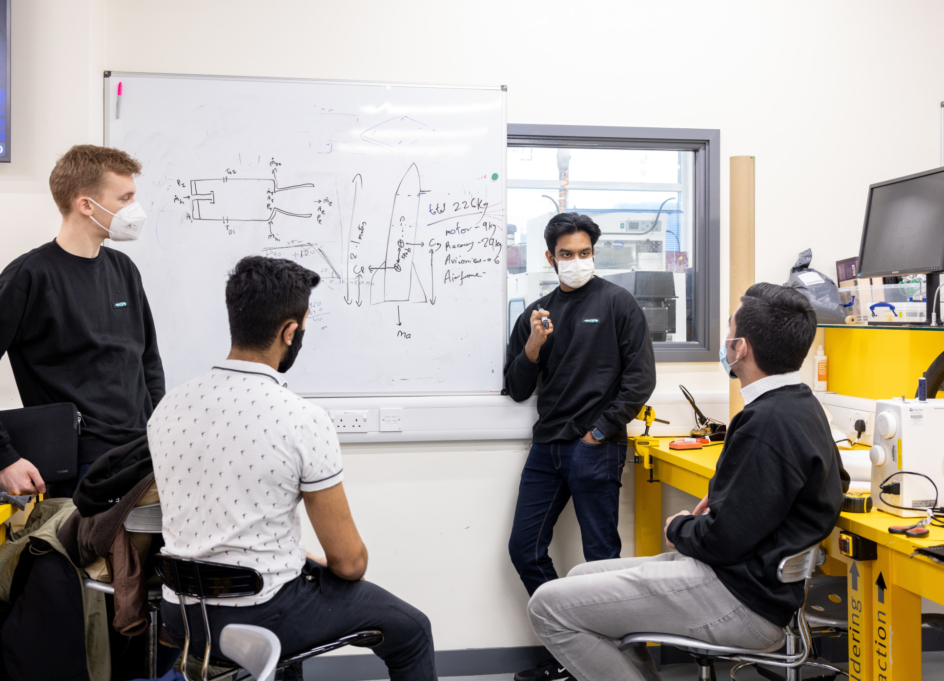 Students gather around a whiteboard