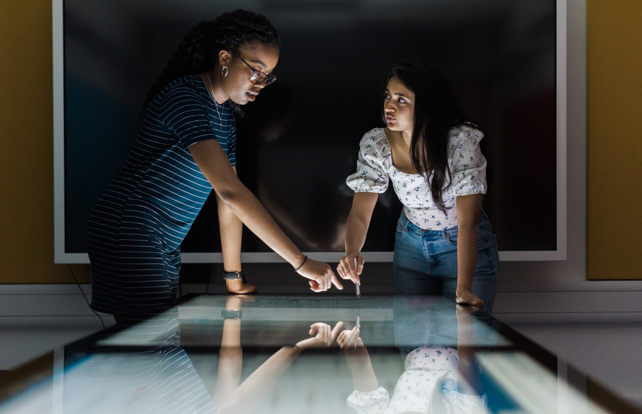 Two scientists standing over their work