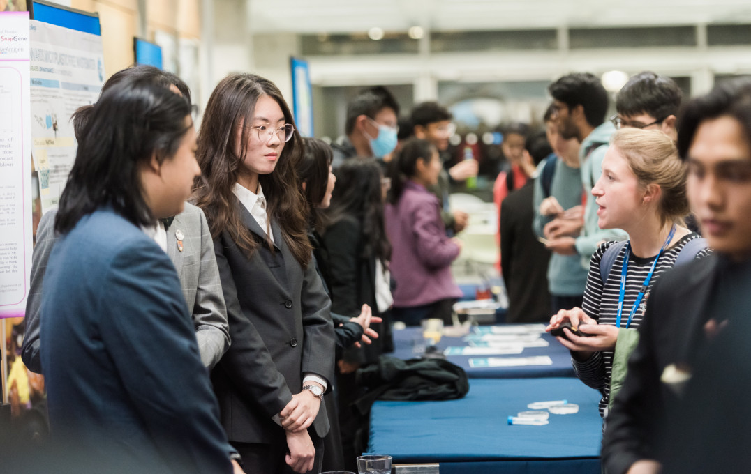 Team AFLT discussing their project with attendees after the final.