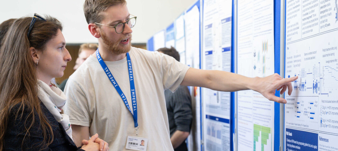 Researcher is pointing to a poster 