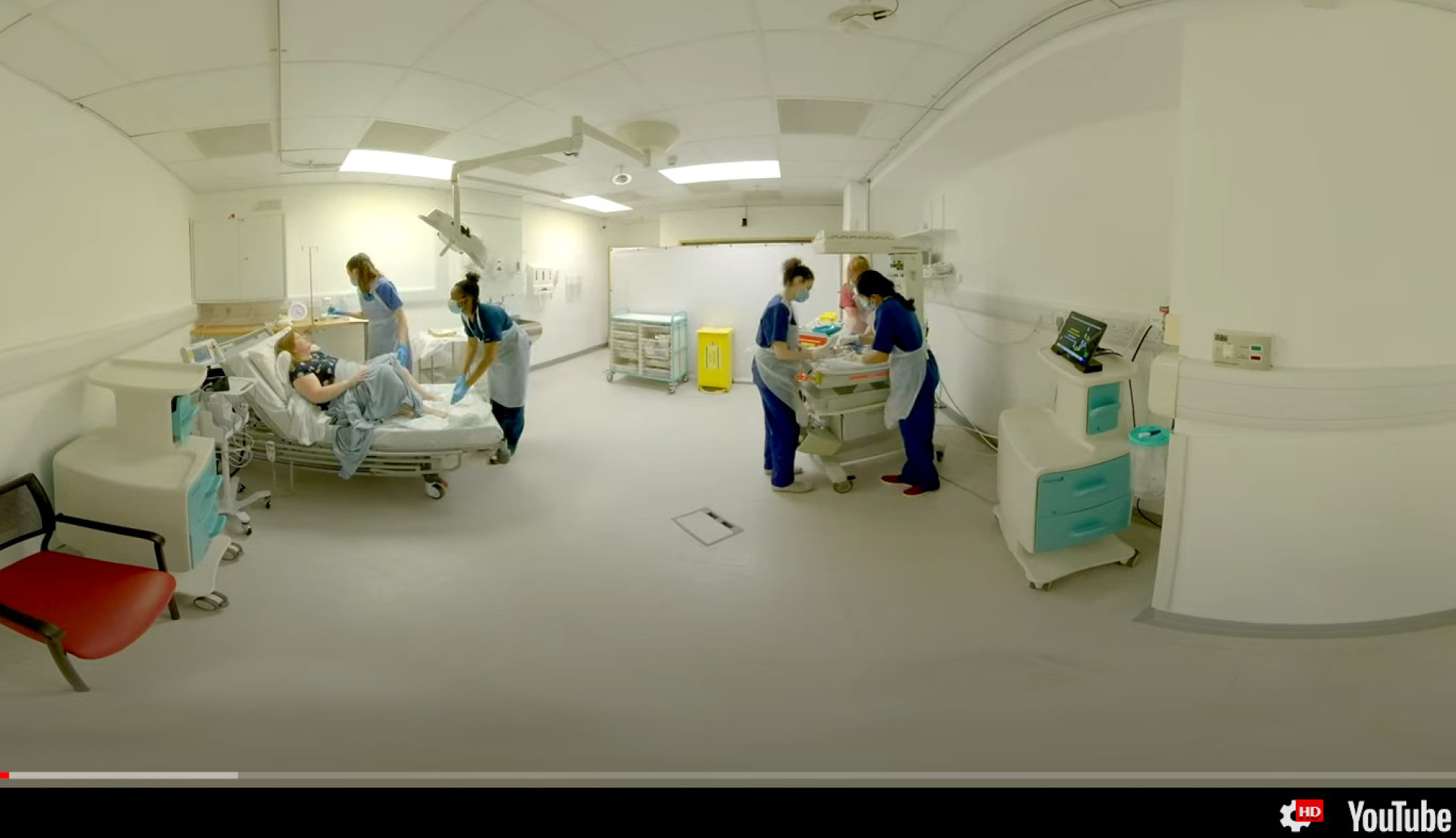 Still from YouTube video showing mother in labour with healthcare staff