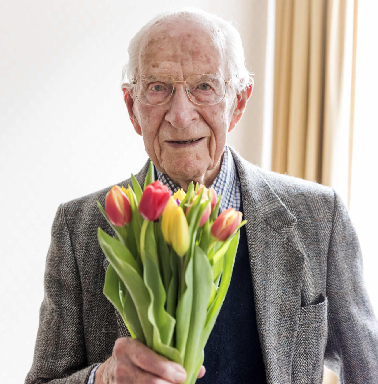 Photo of a smiling Dr Frankland holding flowers