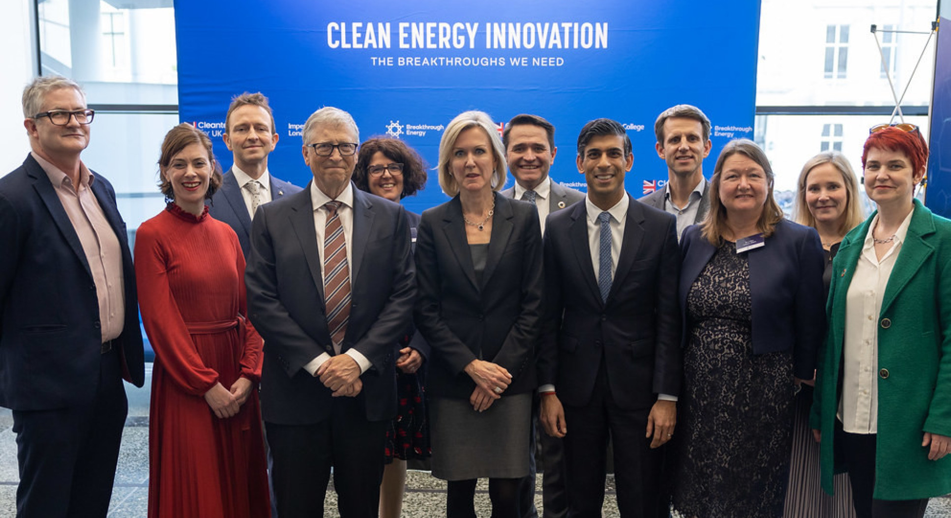 A group of people in front of a sign about clean energy innovation