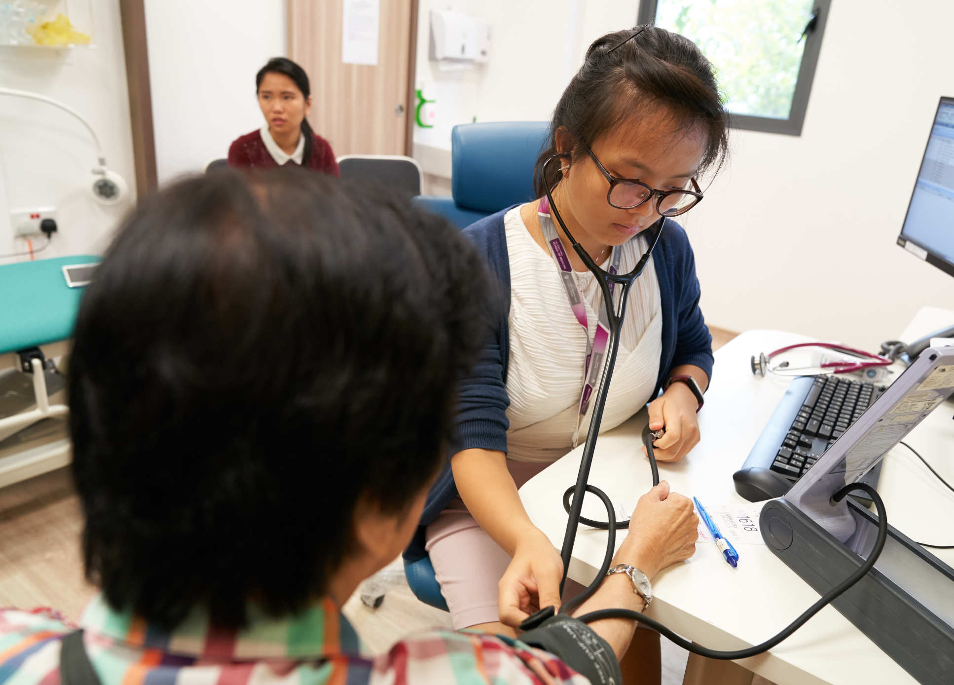 acqueline takes a patient's blood pressure 