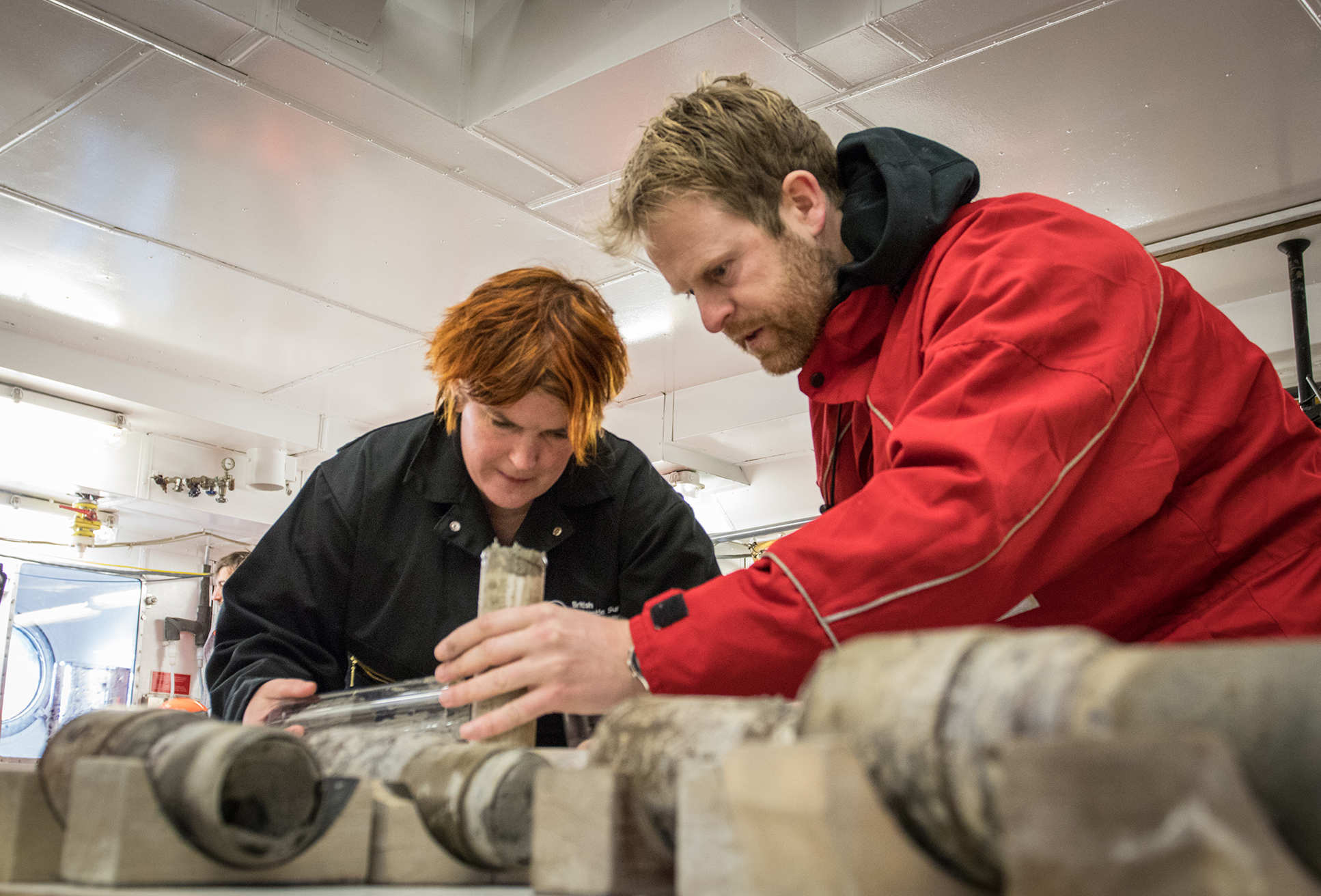 Two people look at cylinders of rock