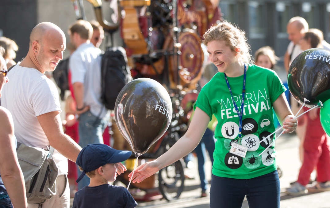 A female volunteer gives a young boy a balloon