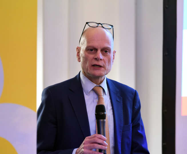 Provost of Imperial College London, Ian Walmsley, standing at a lectern and speaking into a microphone.