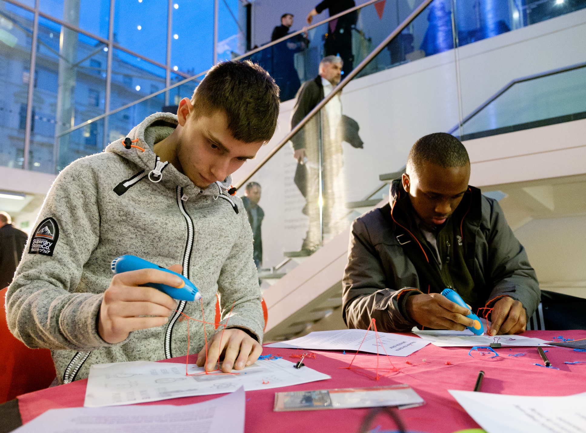 People drawing shapes above a purple cloth