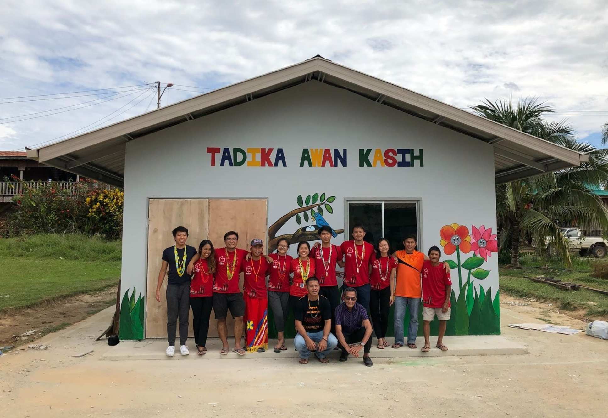 students stand in front of house