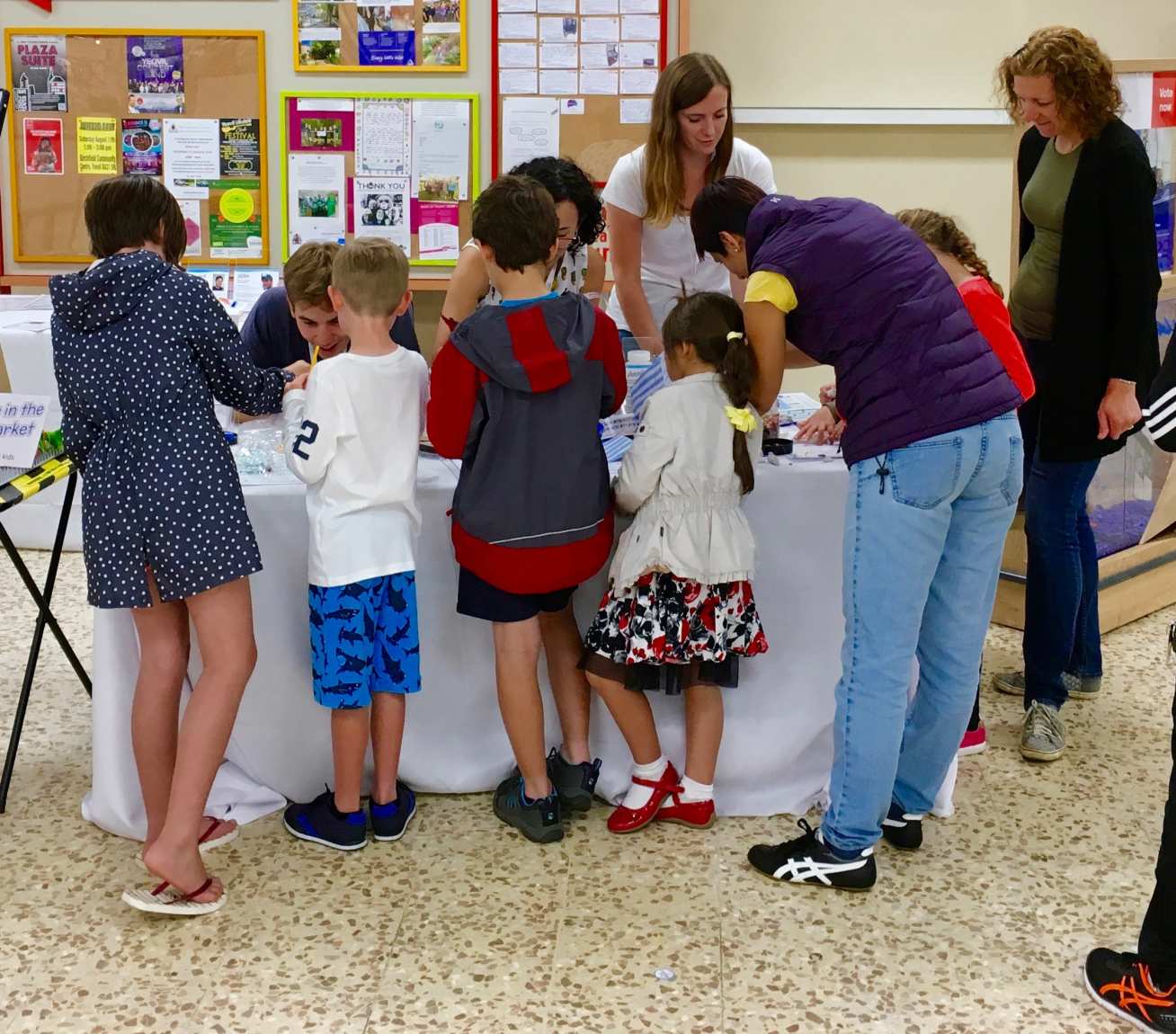 Children speaking to volunteers and interacting with the stand