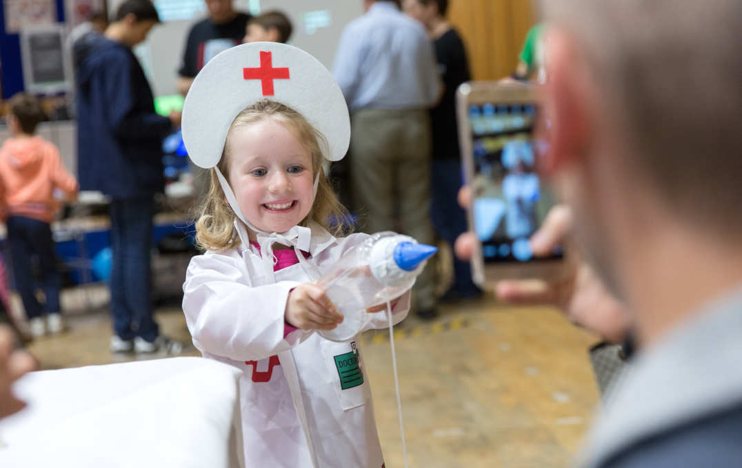 A young girl dressed in a medical outfit