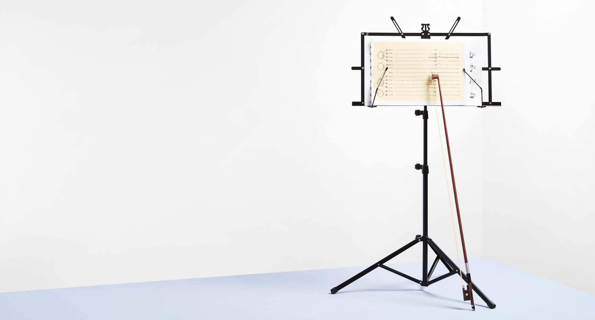 Image of a music stand with a chart and cello bow