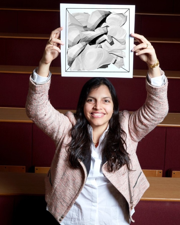 Dr Adriana Paluszny holding Image of rock fracturing planes above her head