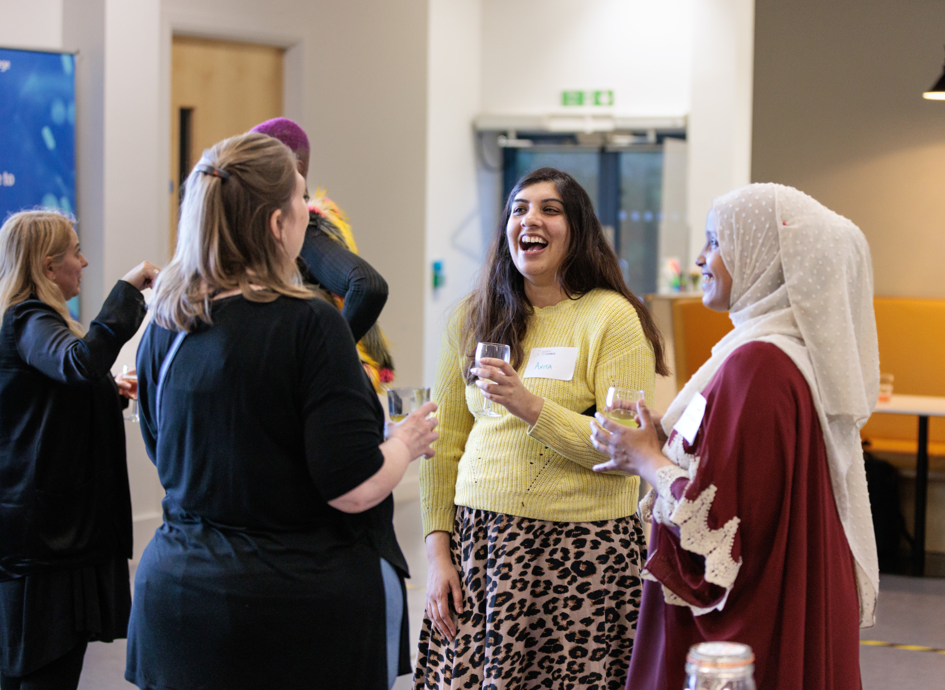 A group of women stand in a circle talking