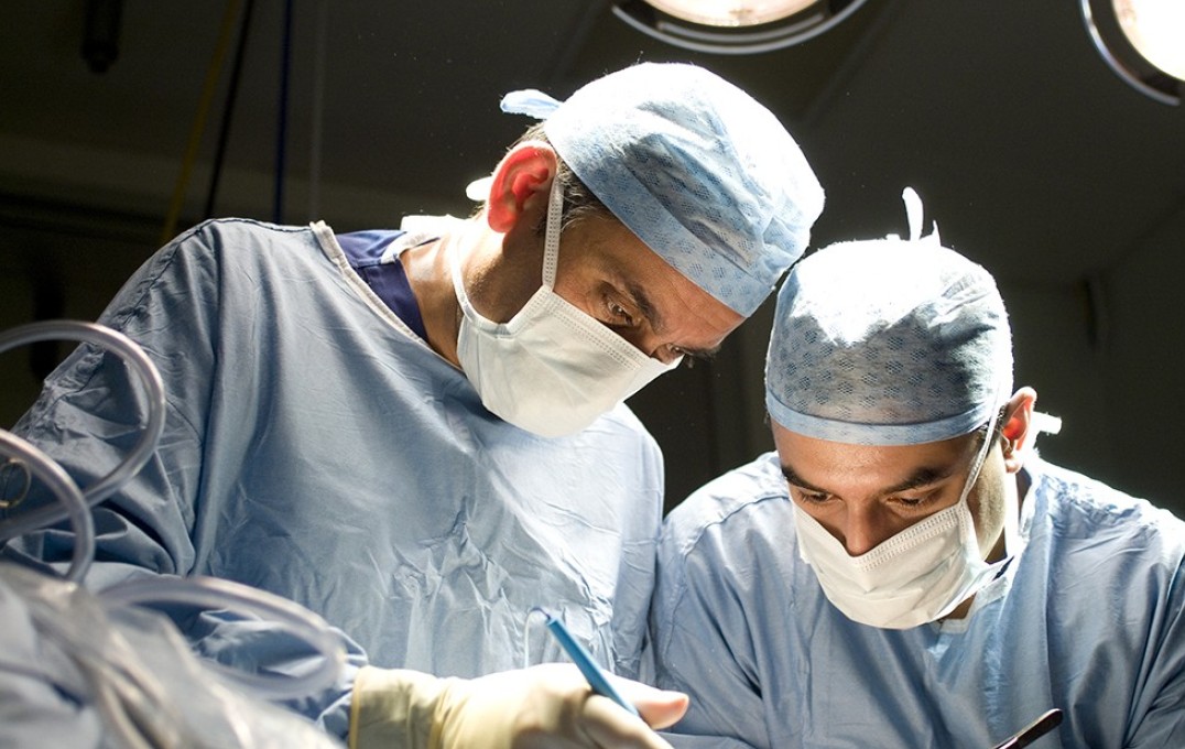 Ara Darzi and Sanjay Purkayastha, wearing surgical masks, operating