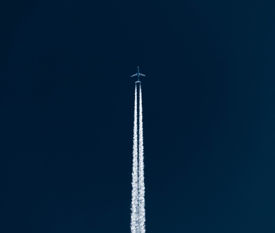 Plane flying far away with large contrails