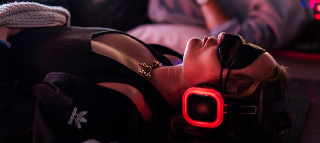 Person laying down wearing headphones and eye mask