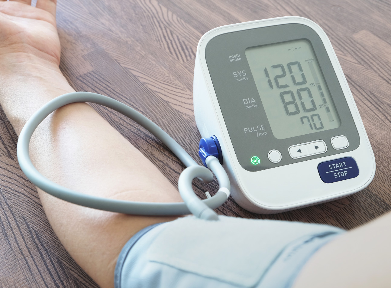 A man uses a device to test his blood pressure. 