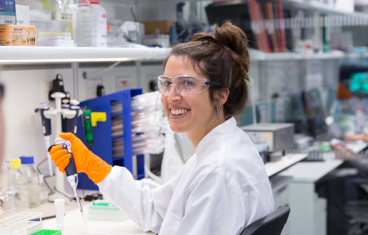 Smiling student in lab with testing equipment