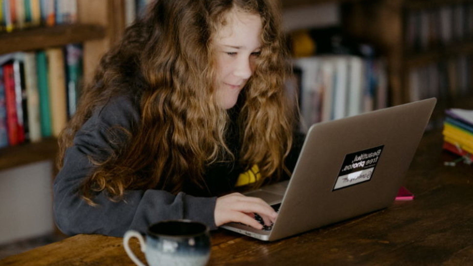 A girl types on a laptop