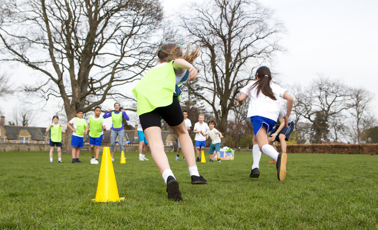 Children playing a sports game on a green field