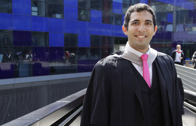 A student wearing robes on graduation day
