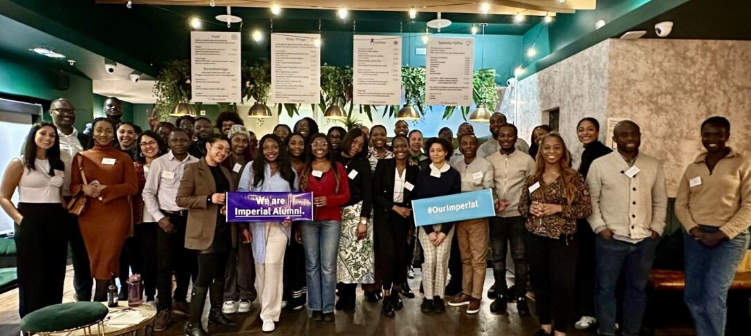 Group photo of around 30+ attendees taken at the last IBAN Spring Social at Bloomsyard Regents Place. 2 members of the group are holding up Imperial branded handheld banners.  