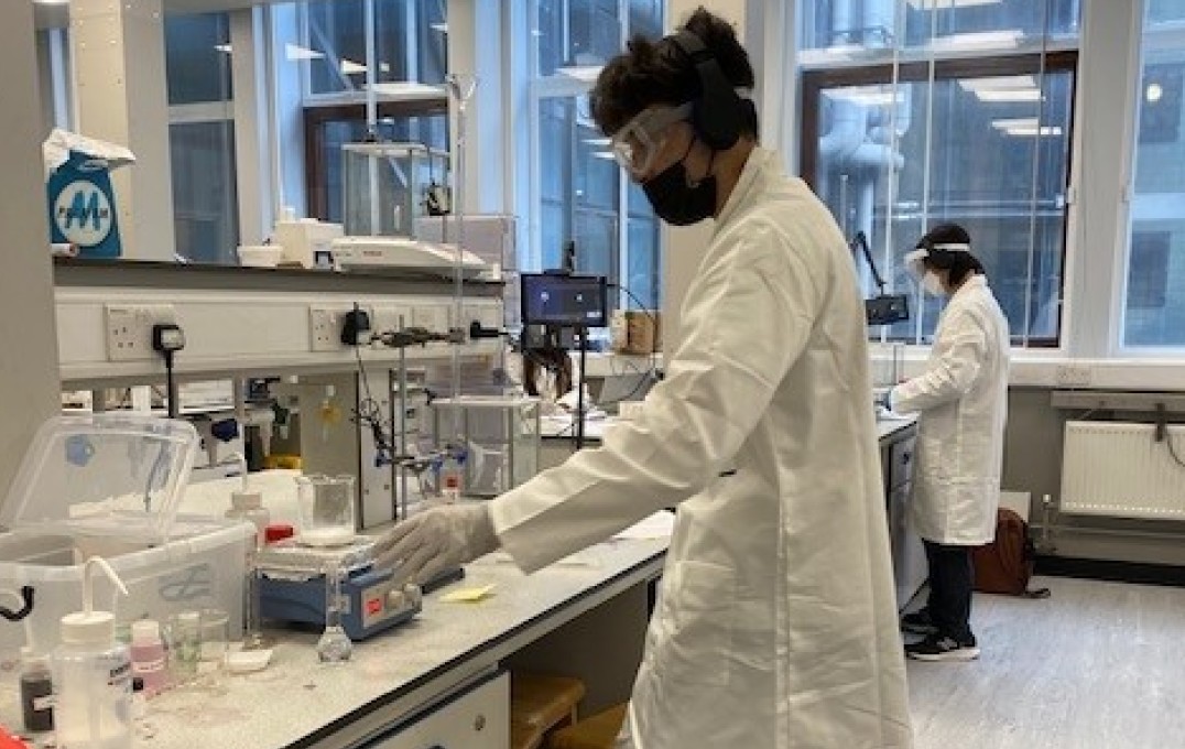 A student doing a titration in the Chemistry Lab with a remote partner connected via Teams on the tablet provided.