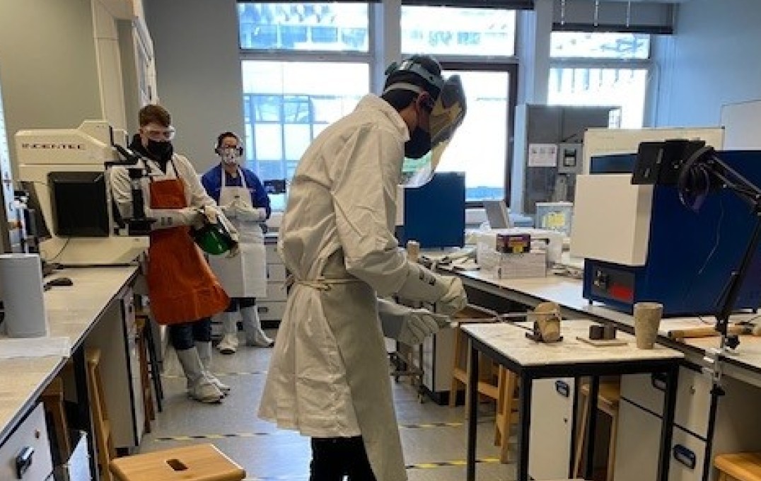 Students conducting casting of metal.