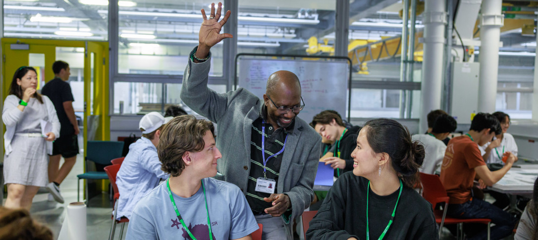 Teacher explaining task to two students at the global summer school