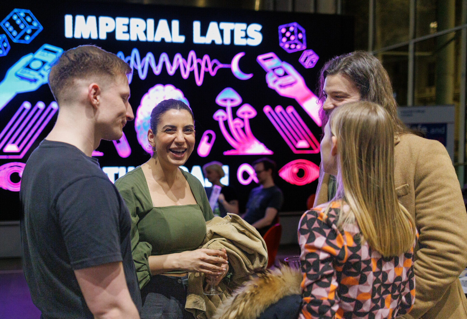 Four friends laughing in front of Imperial Lates sign