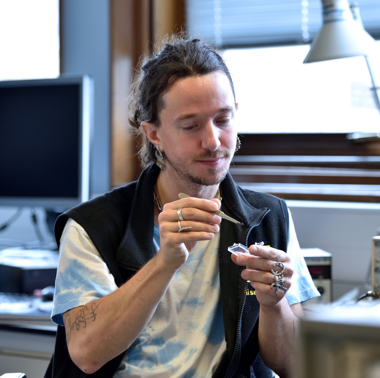 Dr Gartside using tweezers at a lab bench